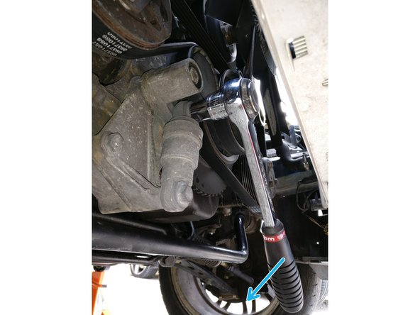 A l'aide d'un cliquet et d'une douille de 13 tourner dans le sens des aiguilles d'une montre (serrage) pour comprimer le tendeur