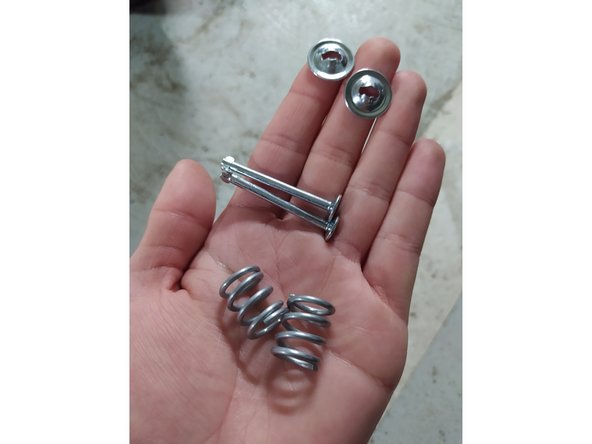 Pour retirer les anciennes coupelles, il suffit de les tourner d'un quart de tour comme on peut le voir avec les coupelles et goupilles neuves fournies avec le nouveau kit.