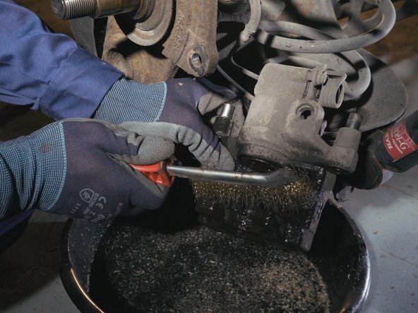 Appliquer du nettoyant frein sur l'étrier de frein et nettoyer l'étrier avec une brosse métallique