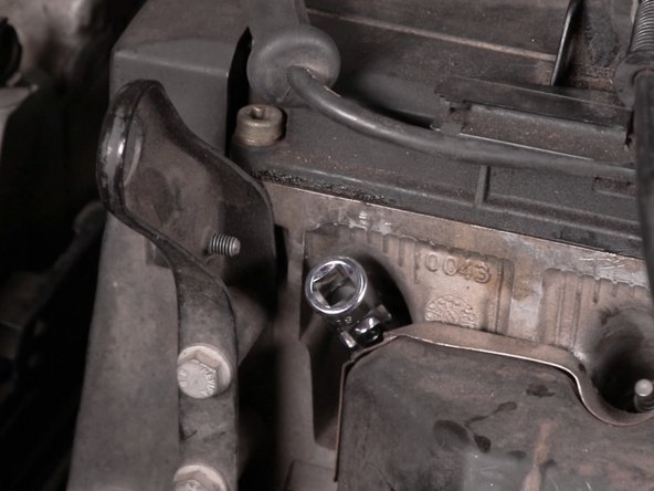 A l'aide du cliquet et de la douilles à cardan desserrer la bougie