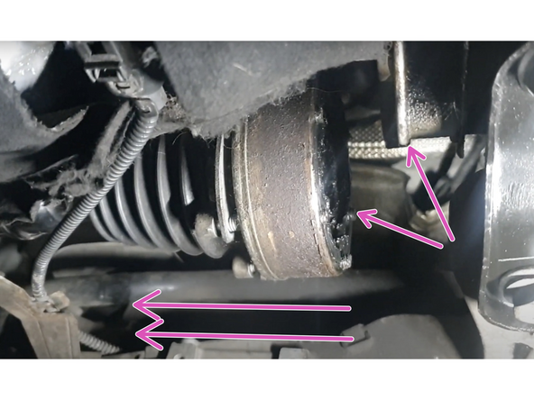 Dévisser les 3 écrous (douille de 16) de la rotule de suspenssion gauche. Dégager le bras en le poussant vers le bas.