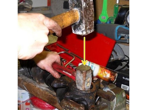 
Reposition the hub on the vice. The bearing ring must be removed from the side of the circlip. Position a mallet or socket on the bearing and use a second mallet to tap it out.
