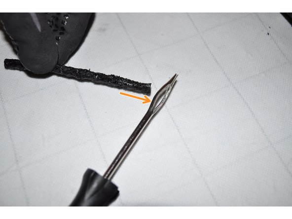 Placer la mèche dans le chas de l’aiguille jusqu’à mi-longueur.