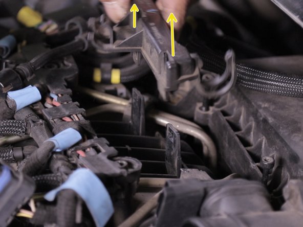 Appuyer sur les deux languettes de chaque coté du support de la pompe d’Amorçage placé devant la boite à, air puis retirer le