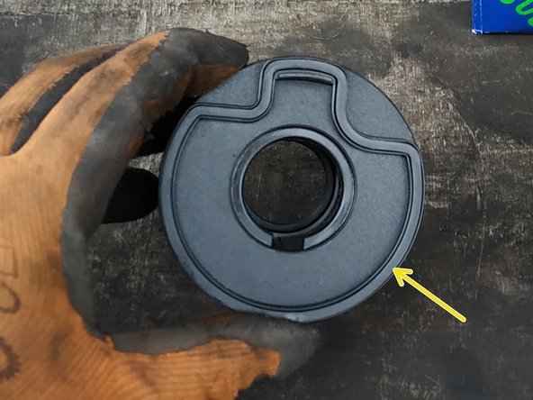 Ne pas perdre le ressort métallique (flèche rouge).