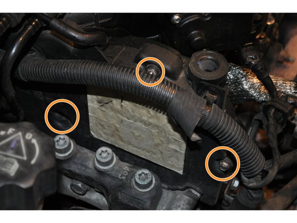 A gauche du moteur se trouve le carter supérieur de la courroie de distribution fixé sur le cache culbuteurs