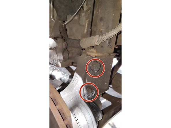 Dévisser les 2 vis du pivot sur la jambe d'amortisseur (écrou de 18)