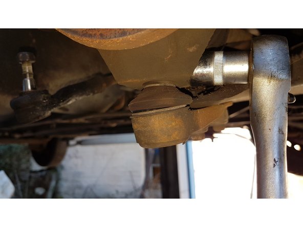 L'écrou de la rotule inférieur se trouve en dessous sous le soufflet de cardan.