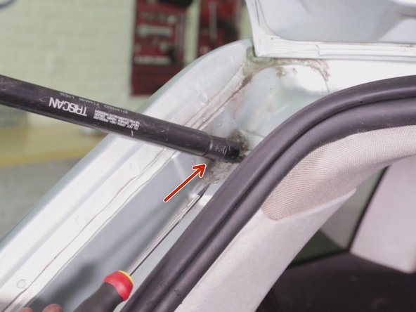 Positionner le tournevis plat entre le clips et le bas du vérin