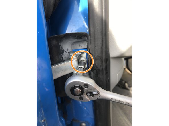 Mettre en place la vis présente derrière l'isolant de la porte à l'aide d'un cliquet ou d'un tournevis porte embouts équipé d'un embout Torx T20 tout en maintenant le cale porte par l'ouverture présente au dessus de la vis.