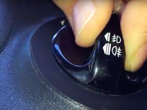 Insérer le petit tournevis à fente et l'enfoncer à fond dans le trou situé sous le bouton de commande en tirant sur celui-ci.