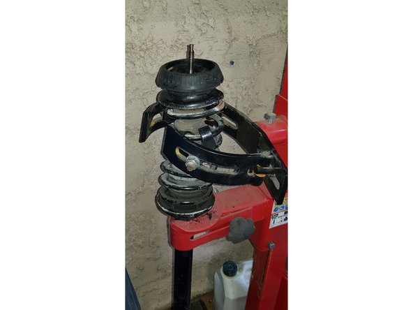 Utilisez votre outil pour compresser le ressort.