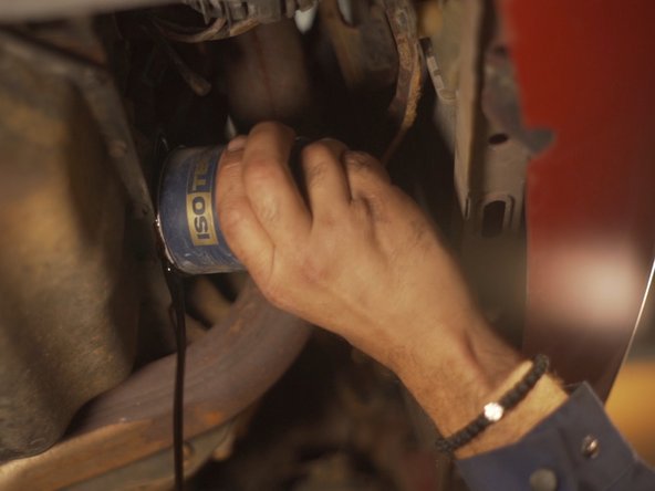 
Remove the oil filter by hand and let the oil drain into the basin
