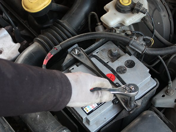 Extraire la bride de fixation de batterie.