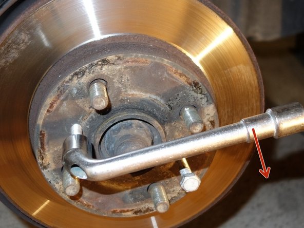 Avec une clé à tube de 13 mm visser progressivement et alternativement  les 2 boulons. Jusqu'au déblocage du disque.