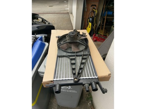 Récupérer également le ventilateur (dévisser les 2 écrous puis le faire glisser vers le bas) et le remonter sur le nouveau radiateur