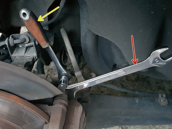 Avec une clé à œil de 13mm