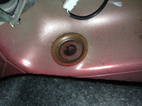 Finir de dévisser l'écrou de fixation en haut de l'amortisseur jusqu'à ce qu'il tombe.