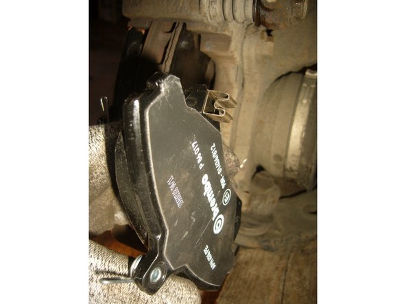 Fixer les avertisseurs d'usure sur les plaquettes neuves comme sur la photo. Ôter le bouchon du réservoir de liquide de frein, et entourer le d'un chiffon afin de repousser le piston le niveau va monter dans le bocal et ça ne doit pas déborder (le liquide de frein est très corrosif).