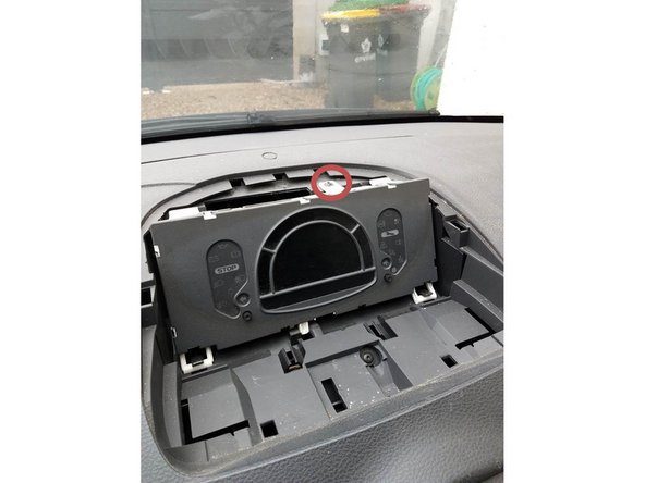 Deviser la vis de fixation du combiné d'instrument puis decliper le combiné en le basculant vers l'avant