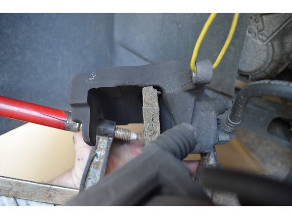 Avec un serre-joint et une cale en bois repoussez le piston au maximum.