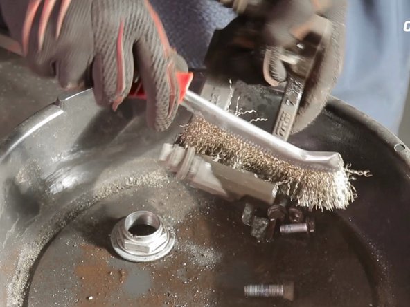 A l'aide de nettoyant frein et d'une brosse métallique, nettoyer le support d'étrier de frein