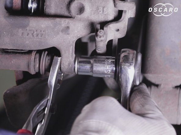 A l'aide du cliquet et d'une douille de 13 resserrer les deux vis de l’étrier en maintenant l'écrou de la chape avec une pince multiprise ou clé de 15 fine