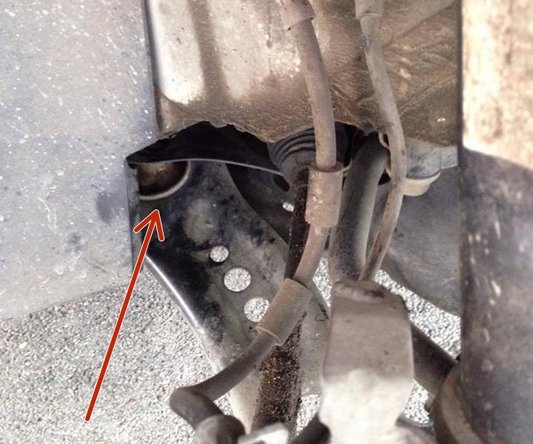 Sur le triangle de suspension côté arrière du véhicule, vous trouverez une fixation avec une vis et un écrou au dessus de celle ci.