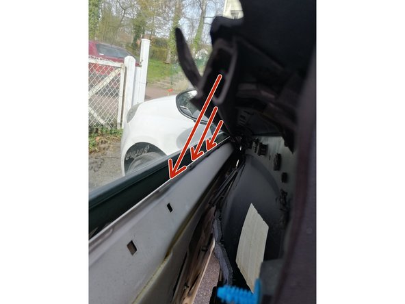 Fixer comme indiqué par les flèches rouges la rainure en plastique dans la lamelle métallique de la porte.