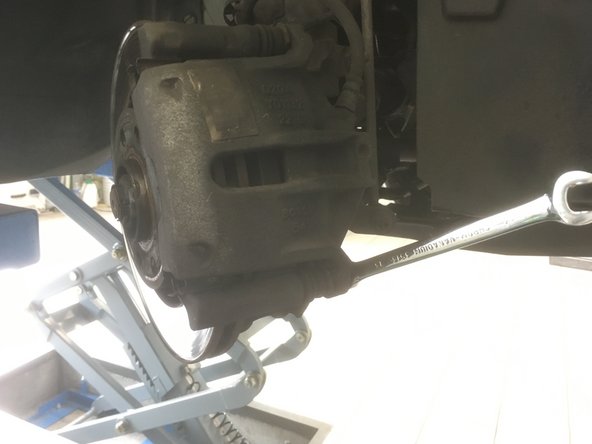 A l'aide de la clé plate de 13, dévisser la vis en bas de l’étrier