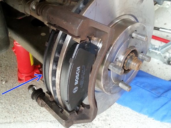 reposer les nouvelles plaquettes, la plaquette avec le témoin d'usure (flèche bleu ) va derrière