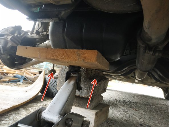 placer un cric et une cale en bois sous le carter d'huile et lever légèrement le moteur