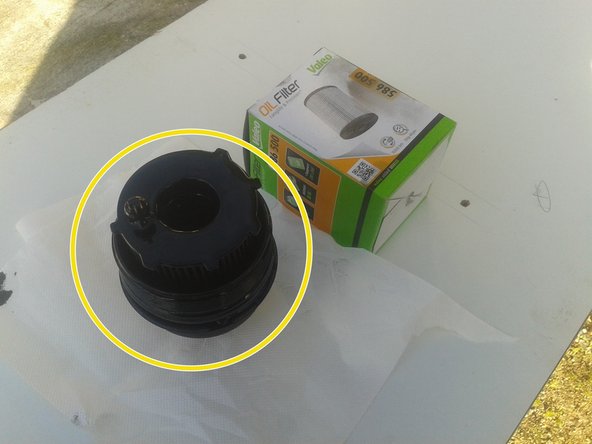 Le filtre à huile reste dans la cloche du filtre à huile, tirer dessus pour l'enlever puis Retirer le joint de la cloche du filtre à huile