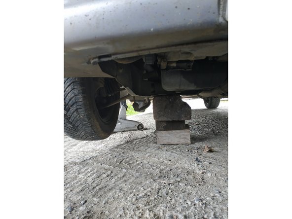lever le côté avant droit de la voiture à l'aide du cric et placer une chandelle sous le berceau ou le longeron