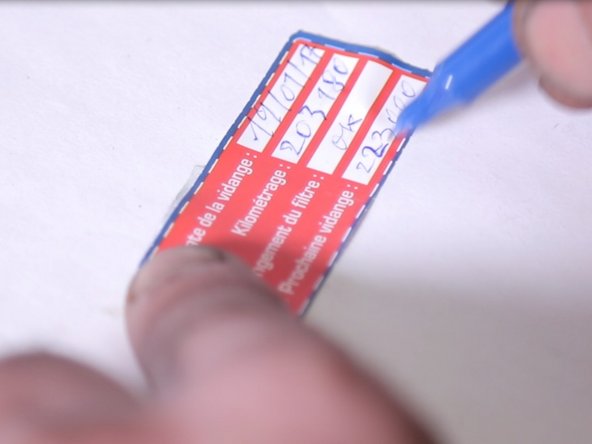 Remplir les informations ( date,kilométrage , prochaine vidange) sur l’étiquette et replacer l’étiquette