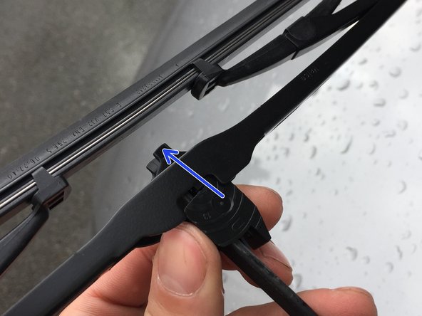 Poussez la languette vers la tige, et poussez en même temps le balais vers le haut de l'attache en U jusqu'à arriver au fond.