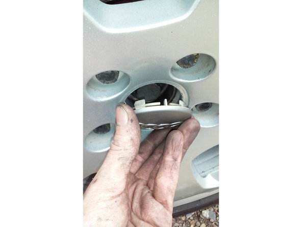 Replacer l'enjoliveur central à la main.