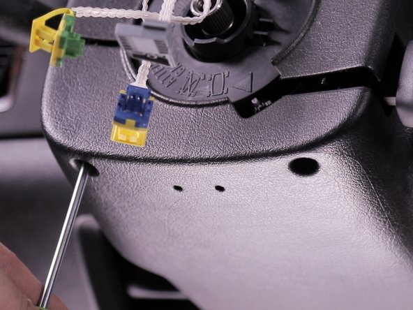 Desserrer les deux vis se trouvant dans la coquille inférieur du volant à l'aide d'un torx T20, ces vis ne se retirent pas