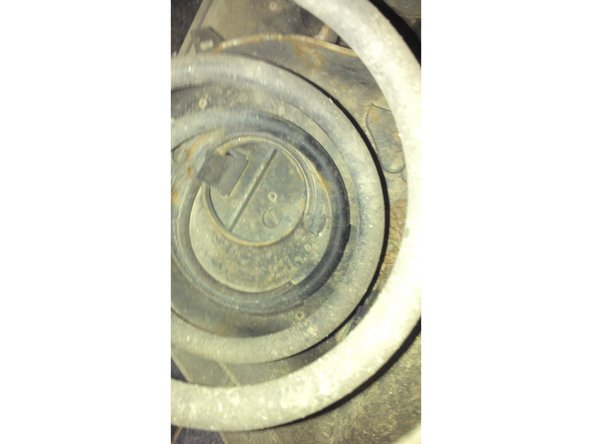 Appuyer  sur les éléments de fixation du cache plastique au niveau du ressort