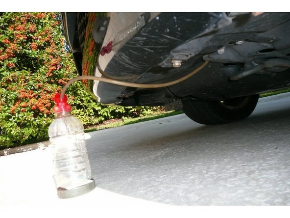 Passer le tuyau par le jeu latéral de la plaque de protection bas moteur