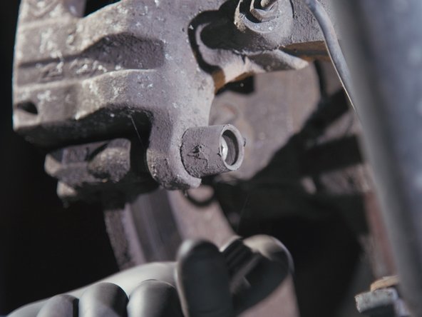 Retirer les deux caches poussière derrière l'étrier de frein