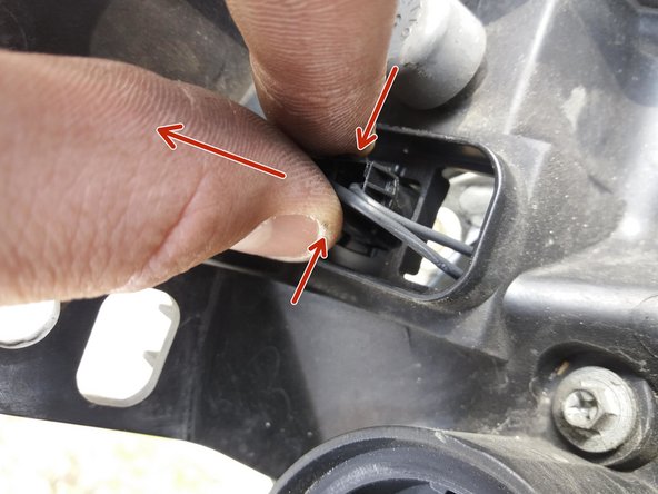 Il faut pincer le support de l'ampoule de feu de position pour pouvoir le sortir du projecteur principal.