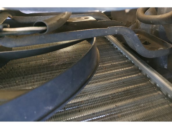 dévisser les 4 vis de fixation du ventilateur sur le radiateur (clé de 7mm, il y a deux vis de chaque côté)