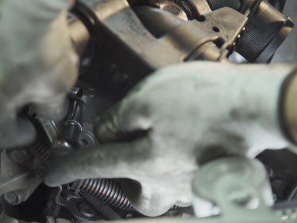 Dévisser les deux écrous présents sous la plaque précédemment retirée avec un cliquet et une douille de 13