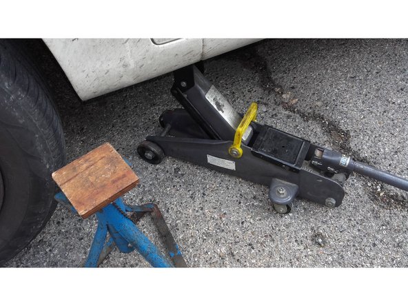 La roue est soulevée du sol grâce au cric et la voiture sécurisée avec une chandelle.