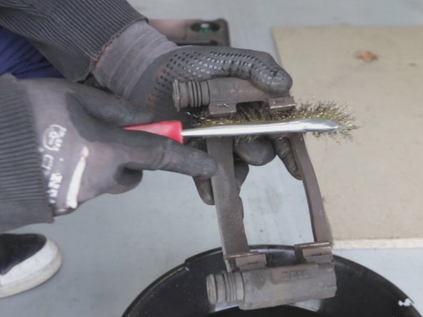A l'aide d'une brosse métallique nettoyer les 4 portées de plaquettes de frein du support d’étrier