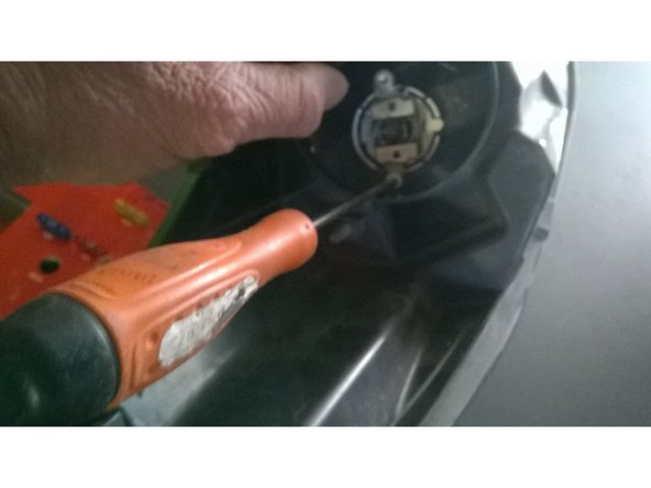 Déposer les deux vis (flèches rouges) qui maintiennent le ressort et l'ampoule à l'aide d'un tournevis torx T25.