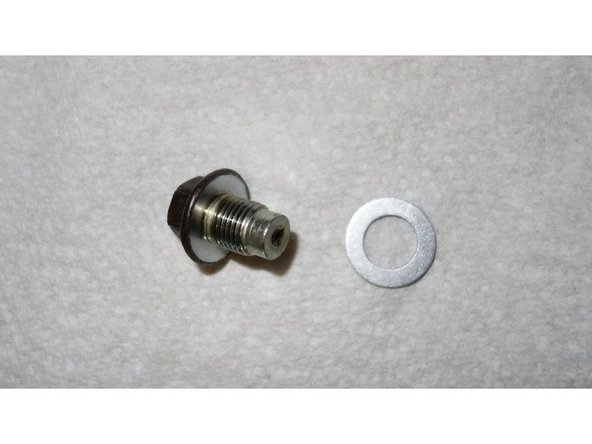 Lorsque l'huile ne s'écoule plus, essuyer la zone de contact du joint sur le carter.