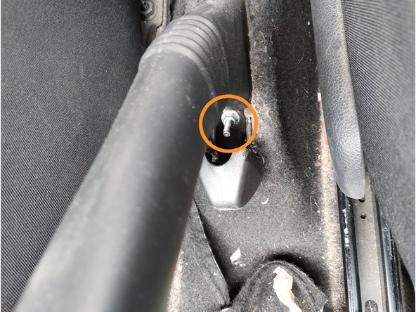 Lever le cache et desserrer le câble de frein à main à l'aide d'une douille de 10 mm