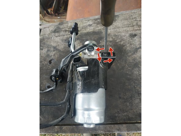 dévisser les 2 vis de maintien de la tôle de protection (une de chaque côté), tournevis cruciforme